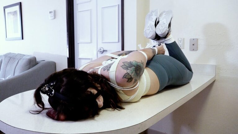 Shaking Frustrated Hogtied Mia Hope Lays Helpless on a Table